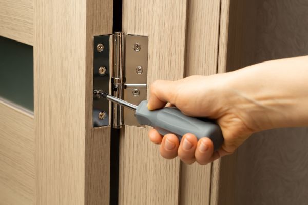 Cửa gỗ phòng ngủ bị xệ cánh, khó đóng: Nguyên nhân và 3 cách tự sửa tại nhà 2 Siết chặt lại ốc vít bản lề